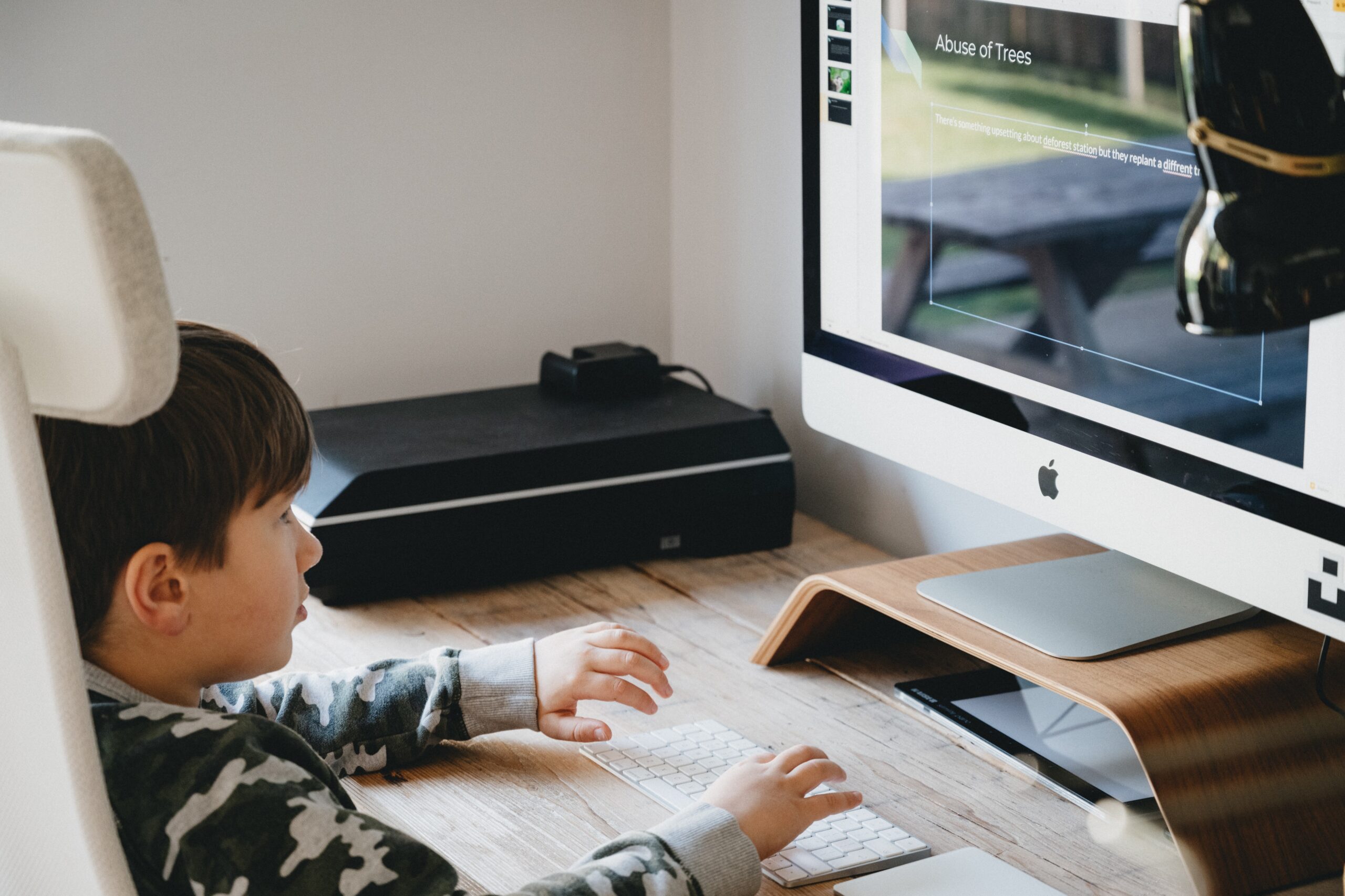 A child using a desktop computer to learn from their home.