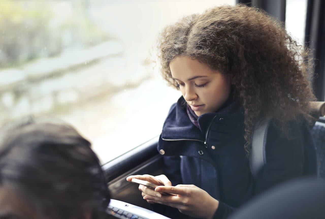 Woman using mobile phone on the bus.