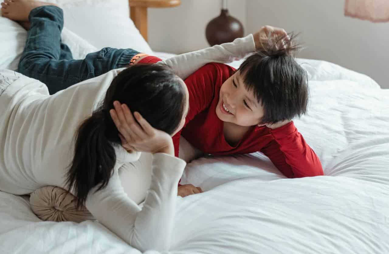 Mother and son lying down on the bed.