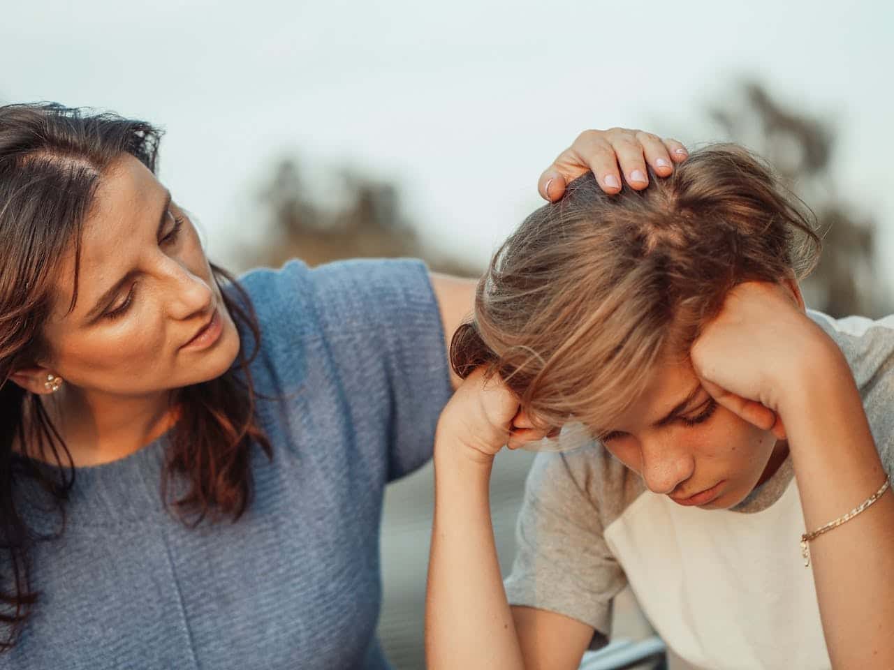 Woman talking to upset teenager.