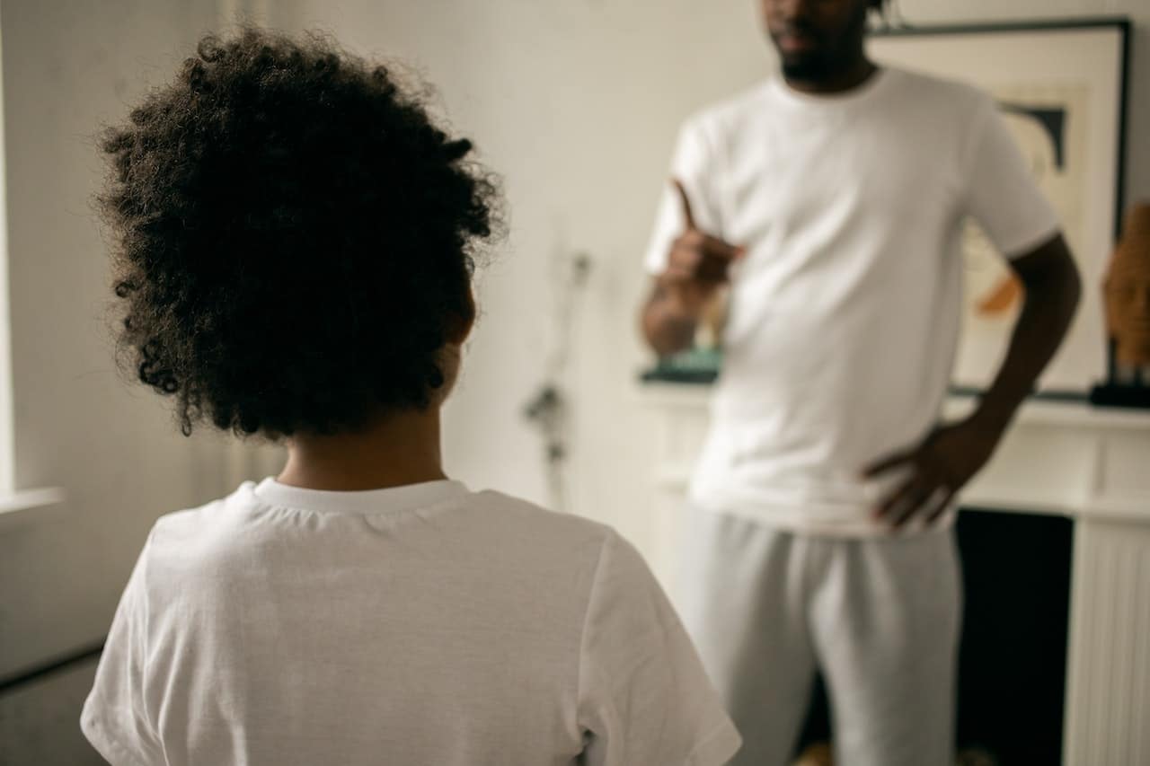 Father telling off child at home.