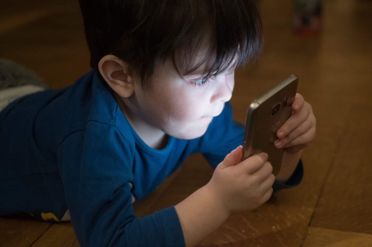 Baby using iphone in dark room.